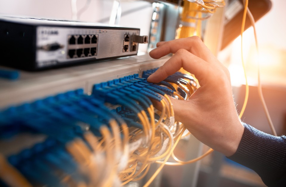 Persona conectando cables en un rack